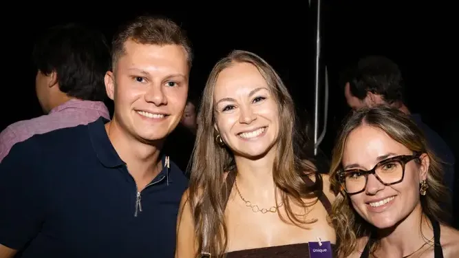 Drei Gäste mit Namensschildern und Drinks